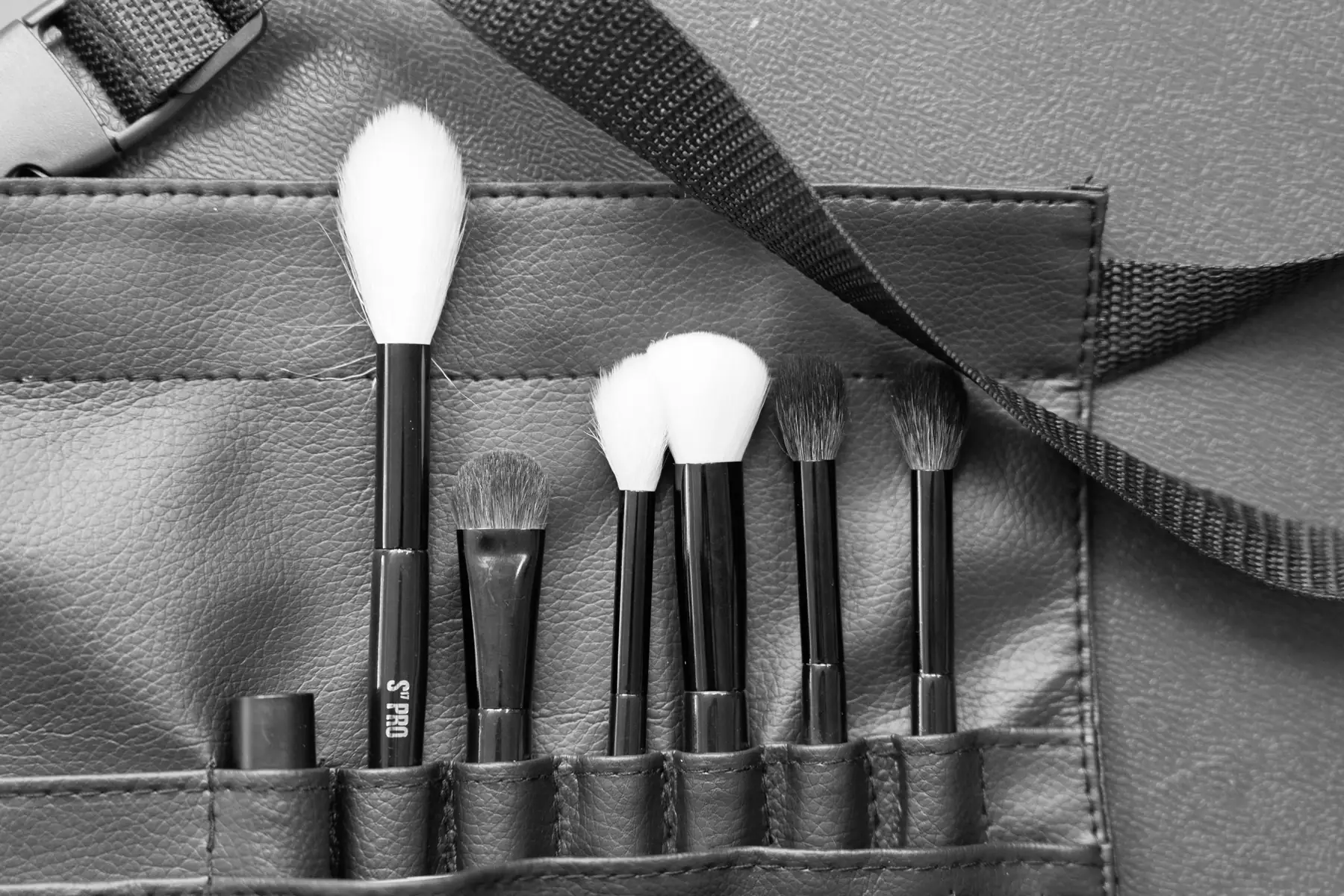 Brochas s17 en el cinturón de trabajo de una maquilladora, en el backstage